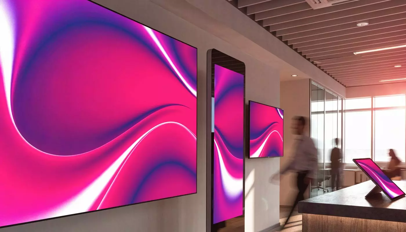 A video wall, a totem and a tablet showing EMITY content in a corporate lobby