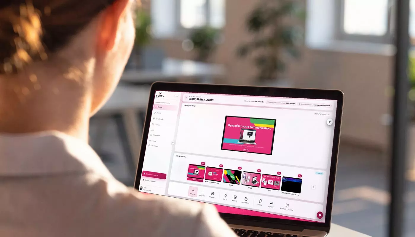 The EMITY E-MANAGER digital signage software interface on a laptop