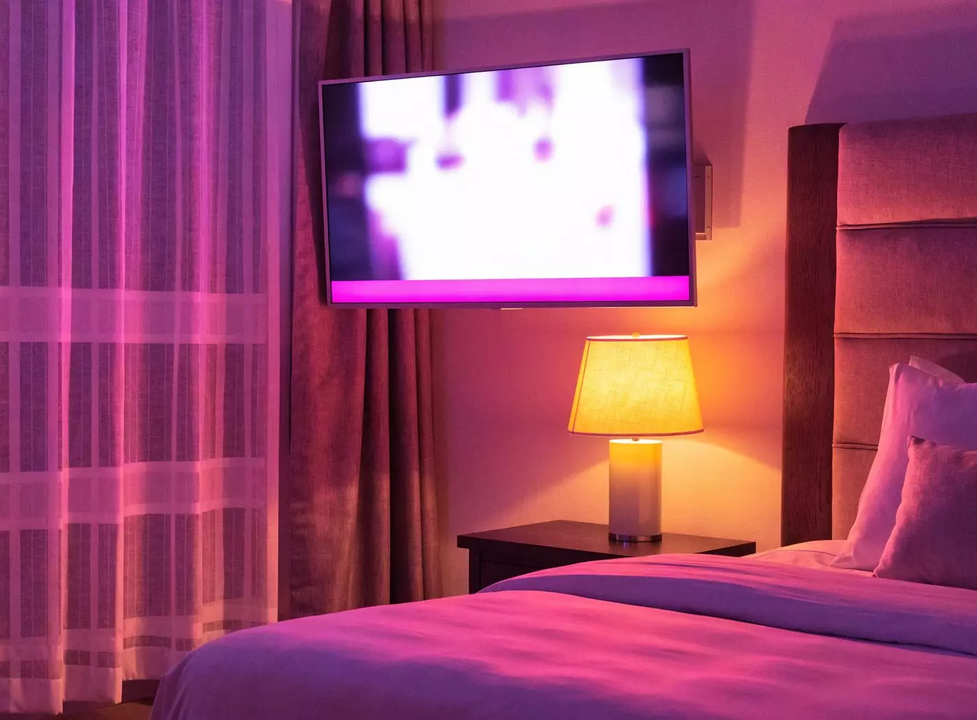 Téléviseur allumé dans une chambre d'hôtel, diffusant les informations du séjour