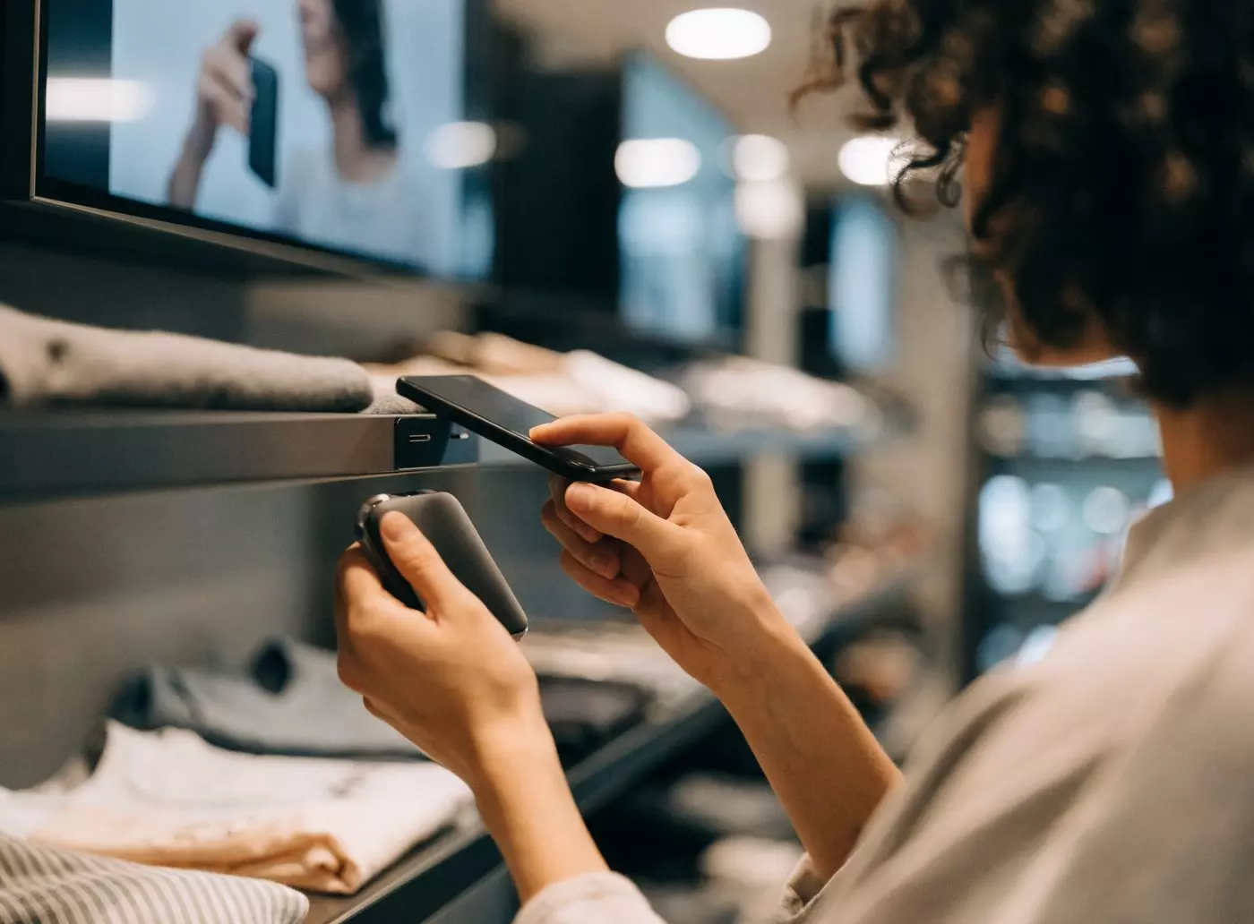 Cliente approchant son smartphone d&rsquo;un tag NFC en rayon