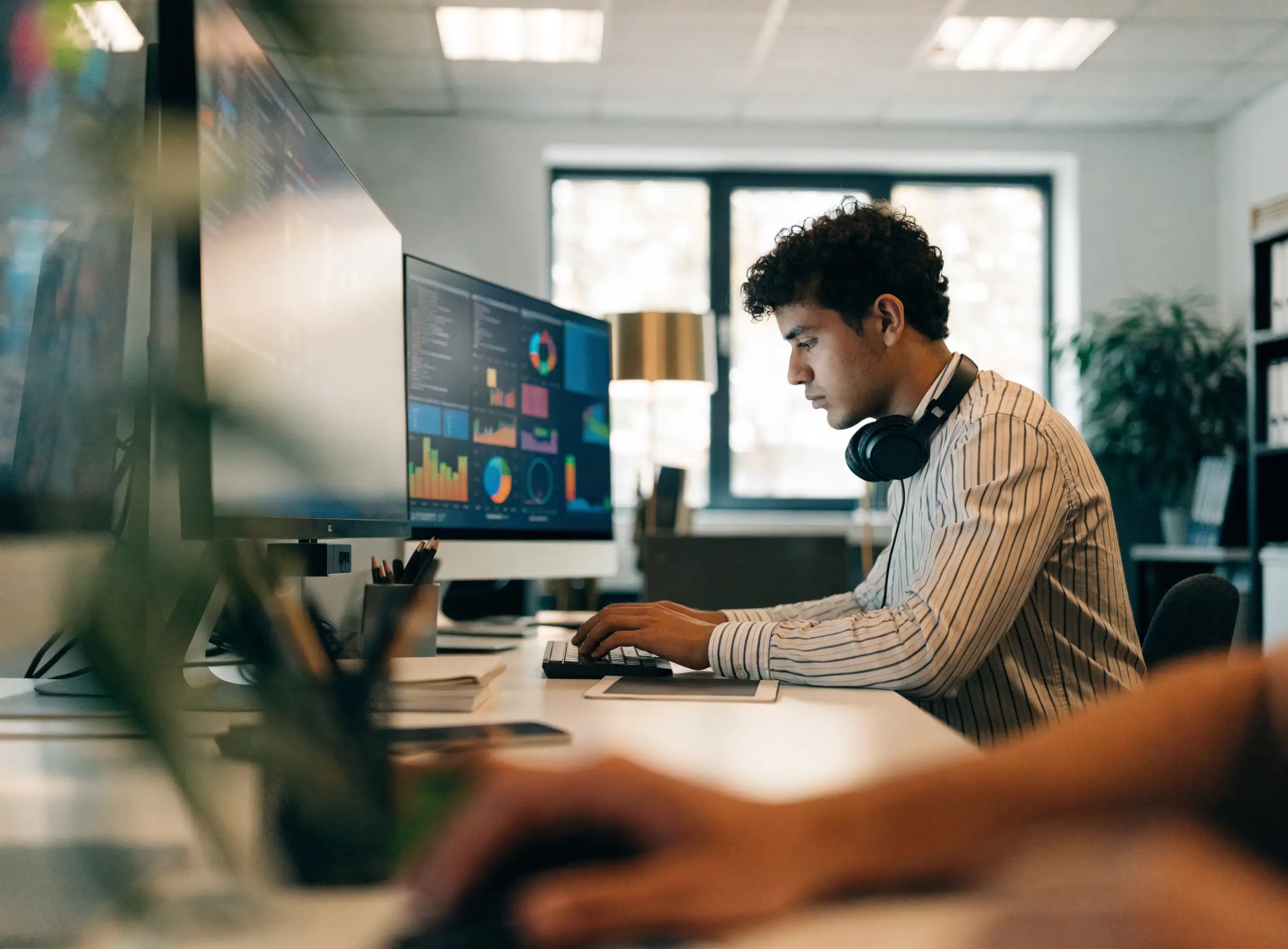 Partner in front of two screens showing dashboards