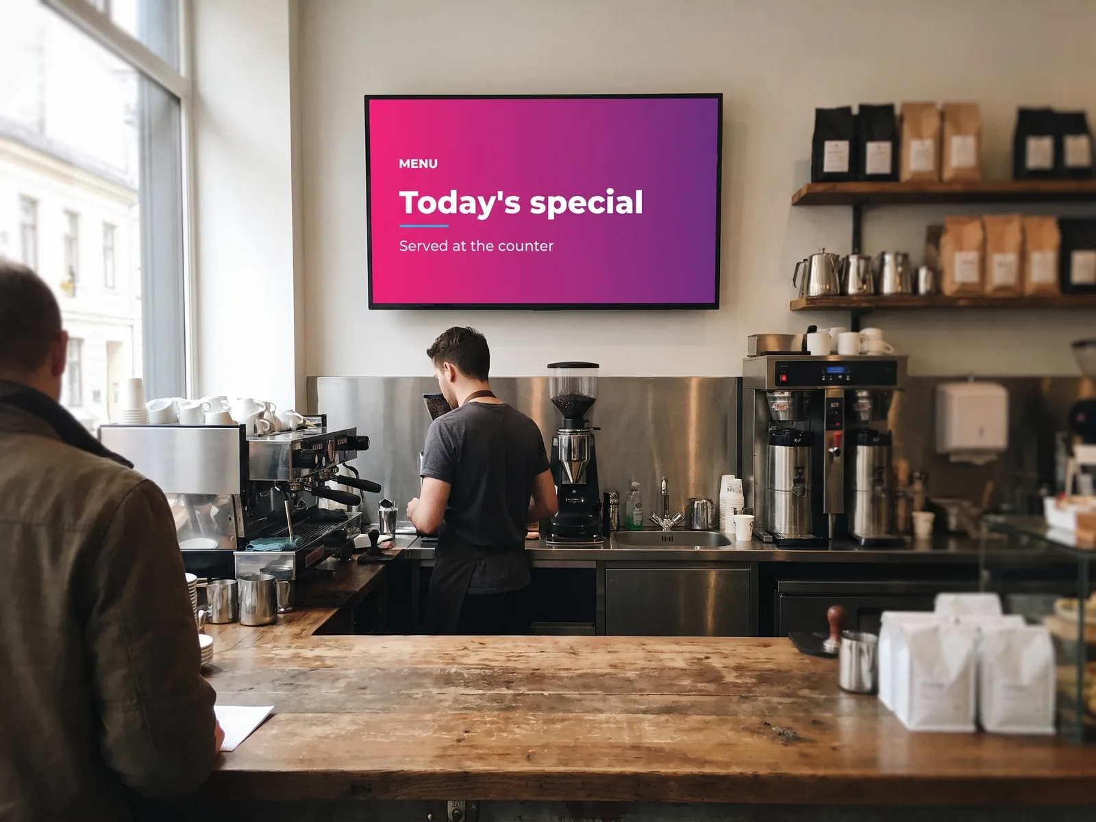 Screen above the barista station of a coffee shop, showing today’s special served at the counter