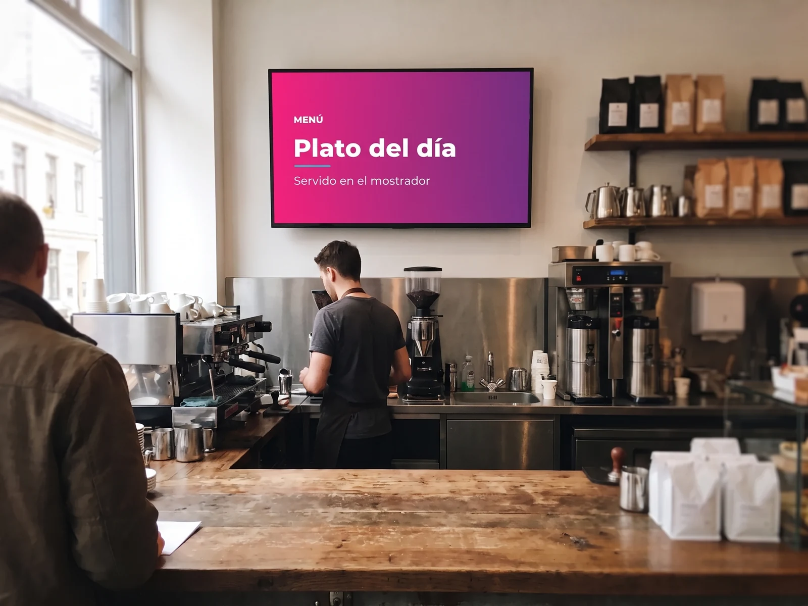 Pantalla sobre la barra de cafetería de un local, con el plato del día que se sirve en el mostrador