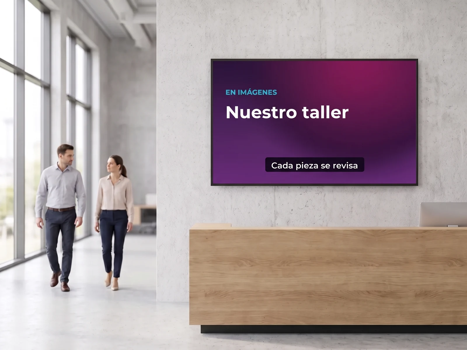 Pantalla de pared en el vestíbulo de recepción de una empresa, que reproduce un vídeo corto subtitulado sobre el taller