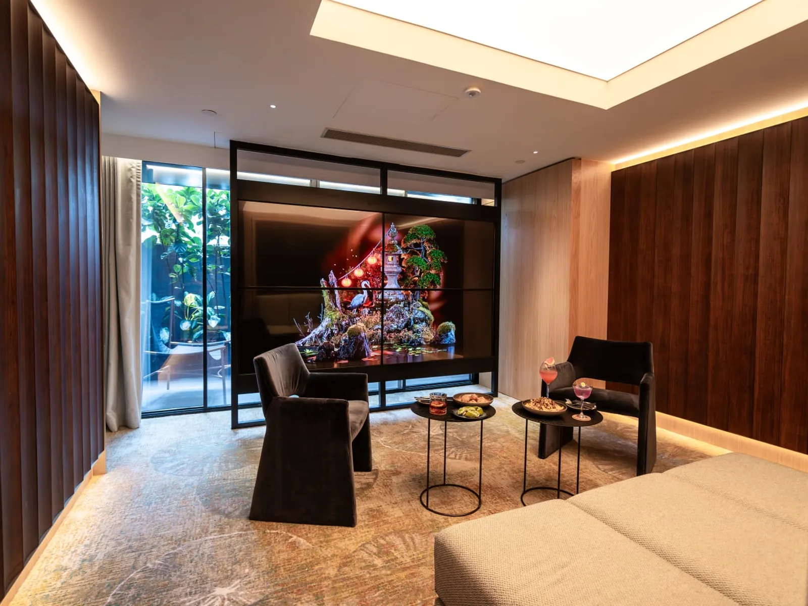 &Eacute;cran diffusant une &oelig;uvre color&eacute;e dans le lobby bois et pierre d&rsquo;un h&ocirc;tel