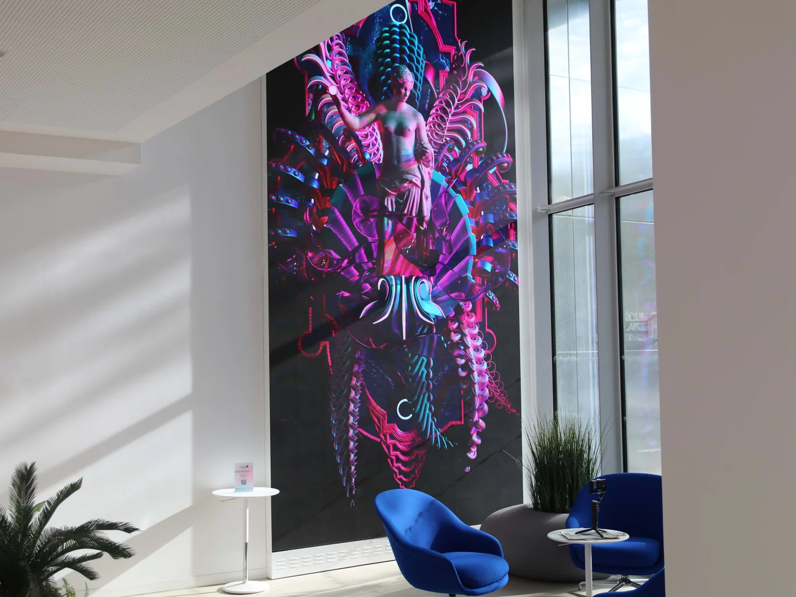 Mur LED vertical toute hauteur diffusant une &oelig;uvre num&eacute;rique dans le lobby lumineux d&rsquo;un si&egrave;ge d&rsquo;entreprise
