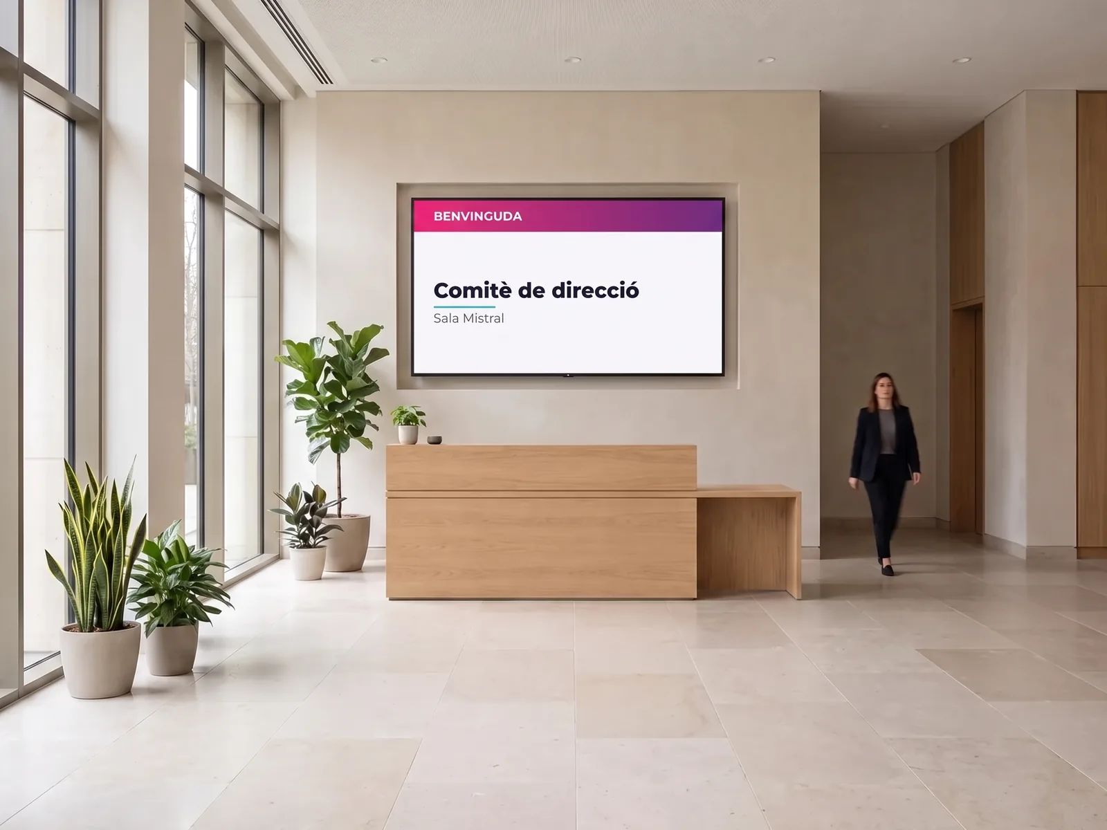 Pantalla mural darrere el taulell de recepció d'una oficina mostrant un missatge de benvinguda
