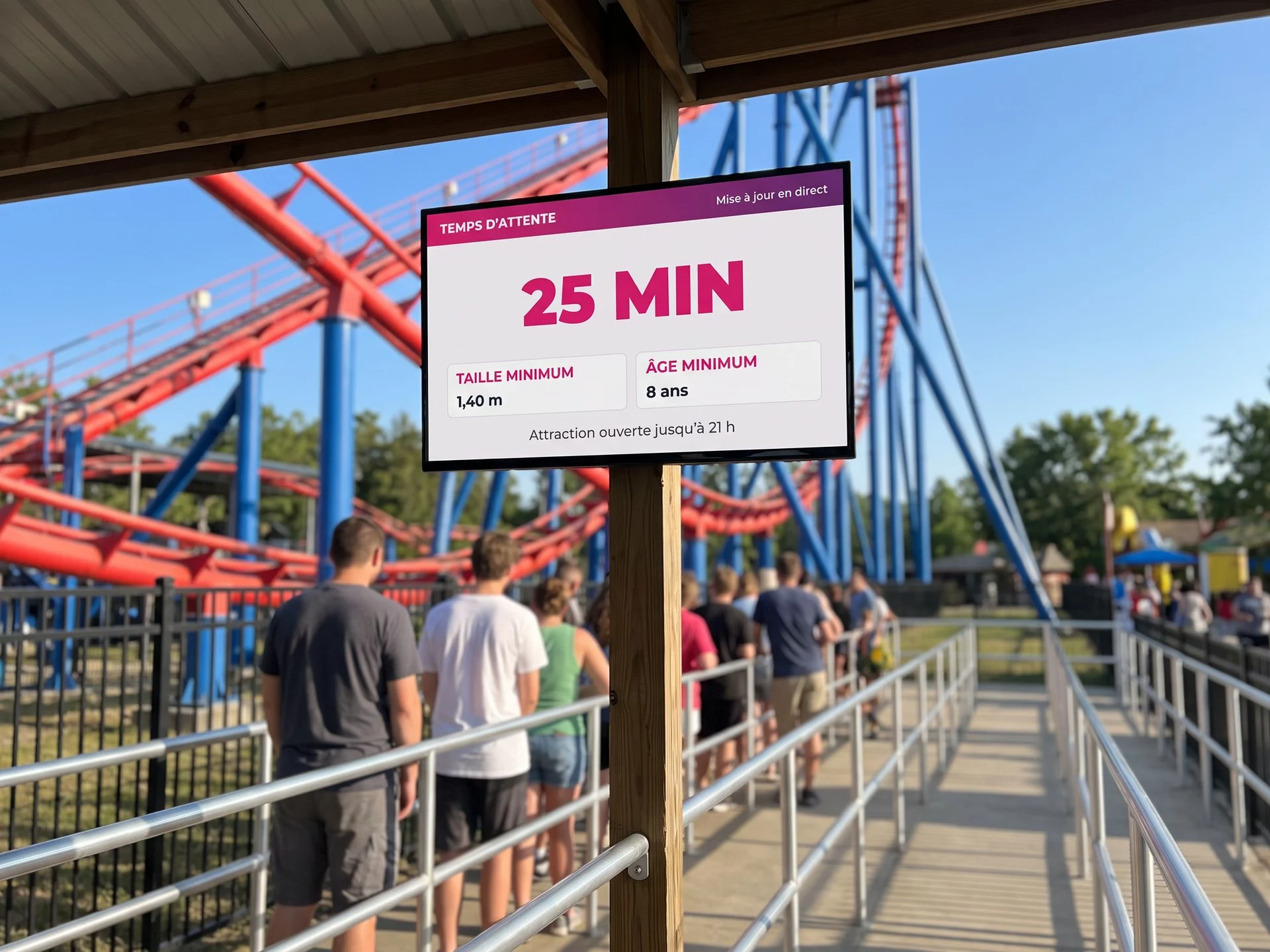 Écran d’affichage dynamique à l’entrée de la file d’une attraction, annonçant 25 minutes d’attente, la taille et l’âge minimum