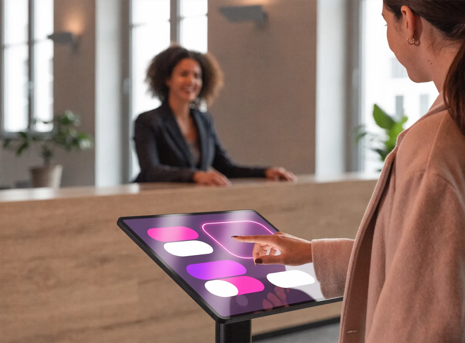 Visitor checking in on a touch-screen kiosk in a company reception lobby