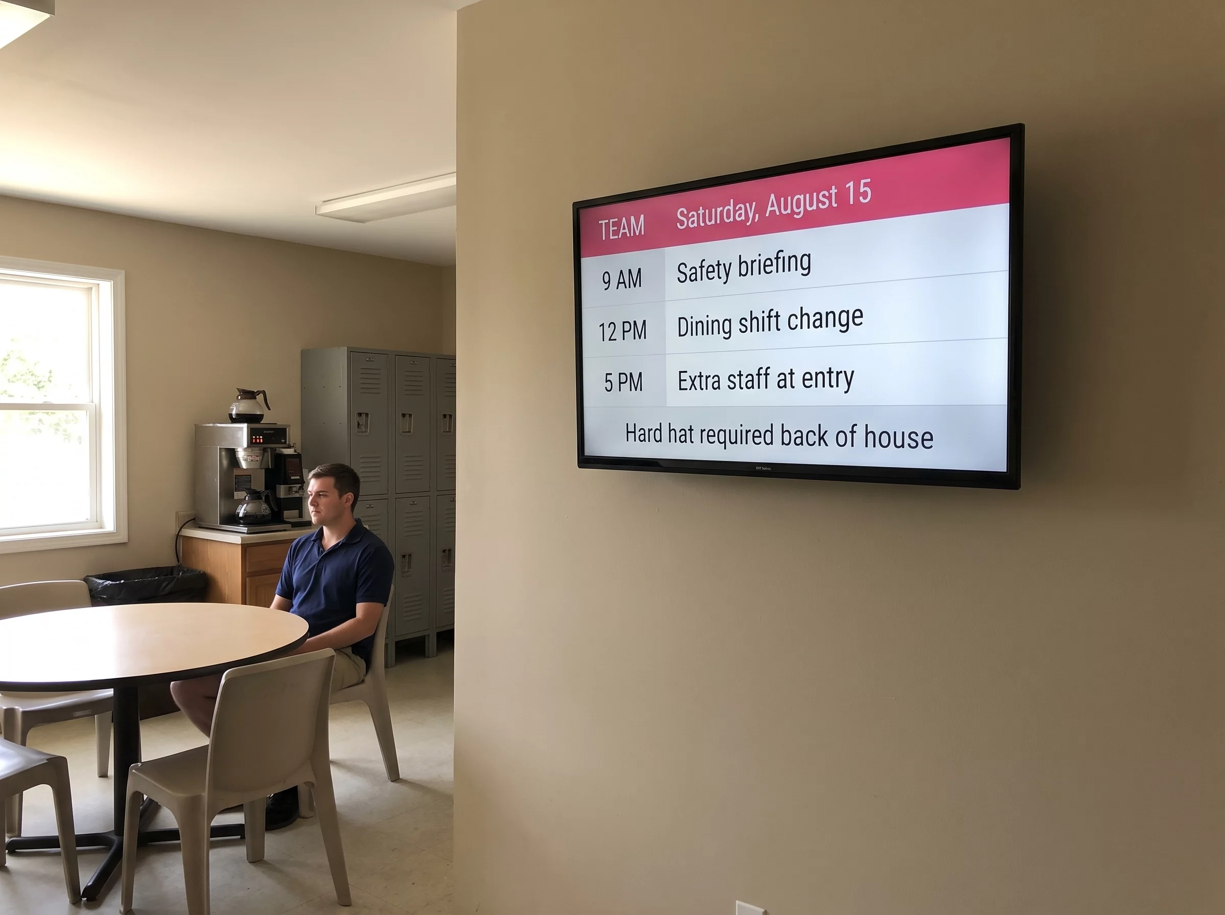 Wall screen in the break room of a theme park, showing the day’s shift plan and a safety instruction