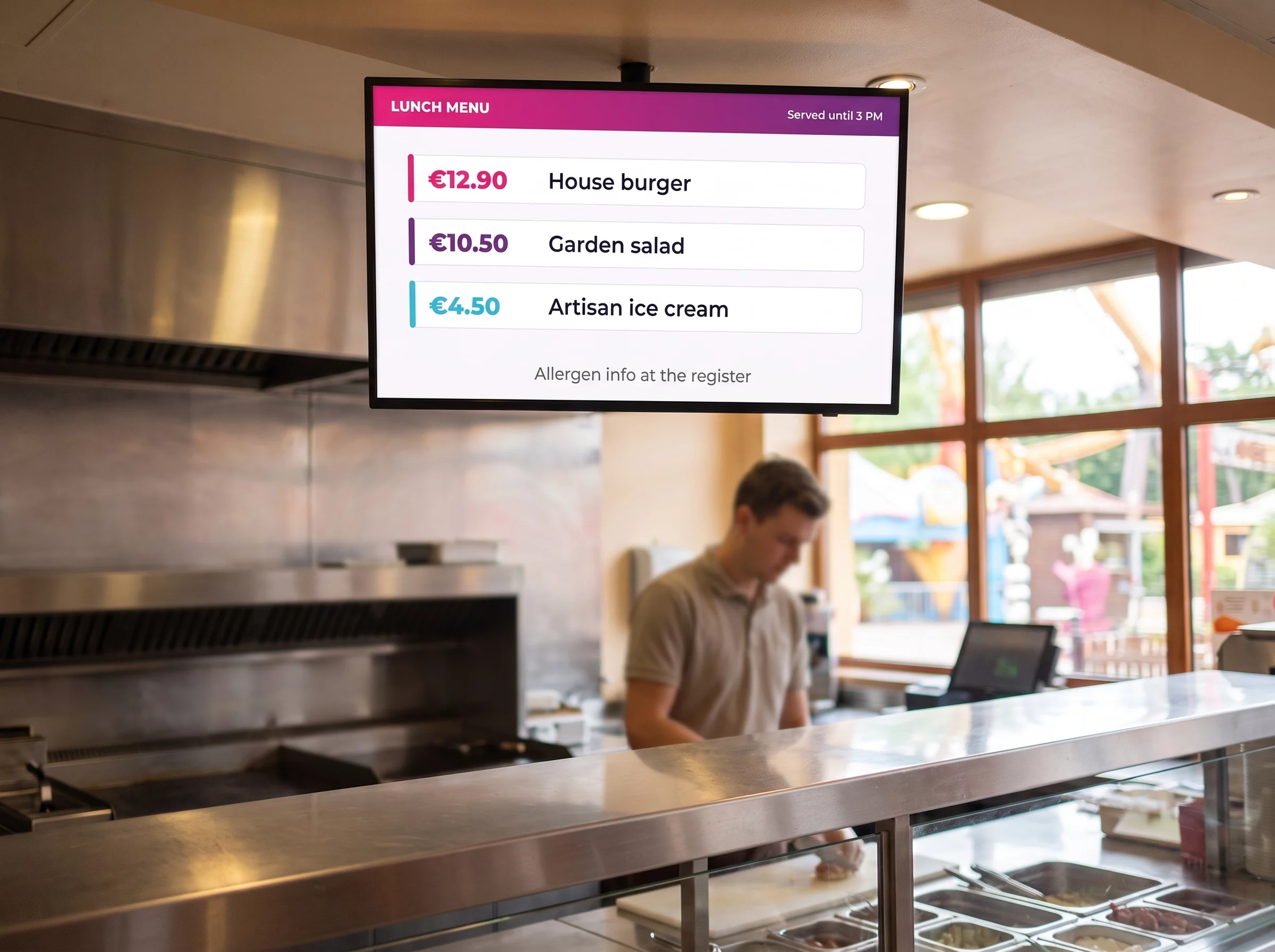 Digital menu board above the counter of a theme park quick-service restaurant, showing three items and their prices