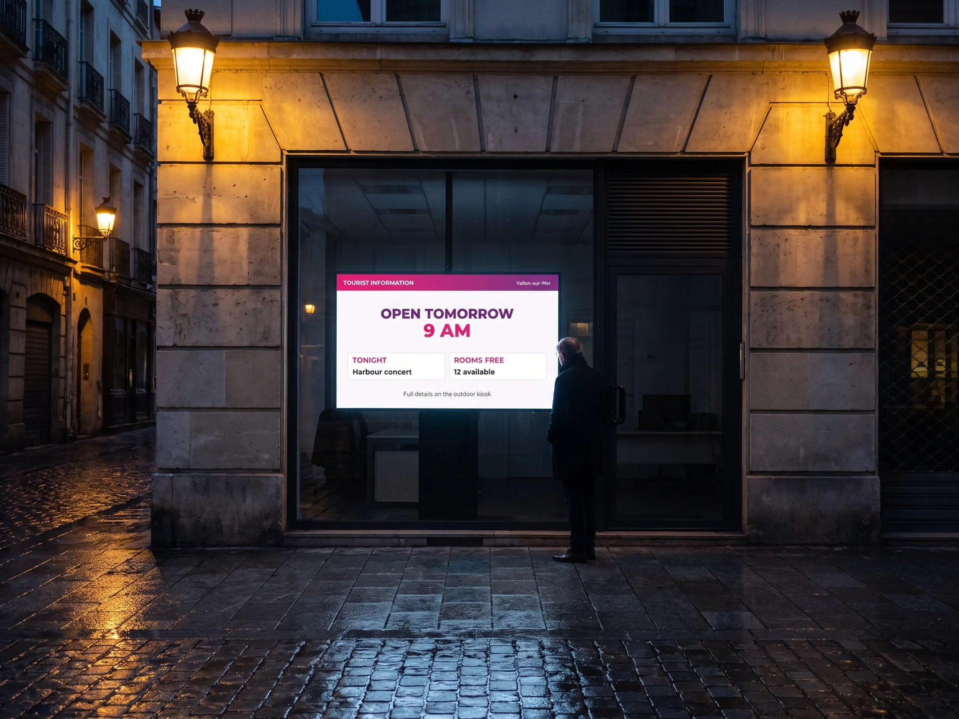 Digital signage screen in the window of a closed tourist information centre at night, showing the opening time and the evening’s events