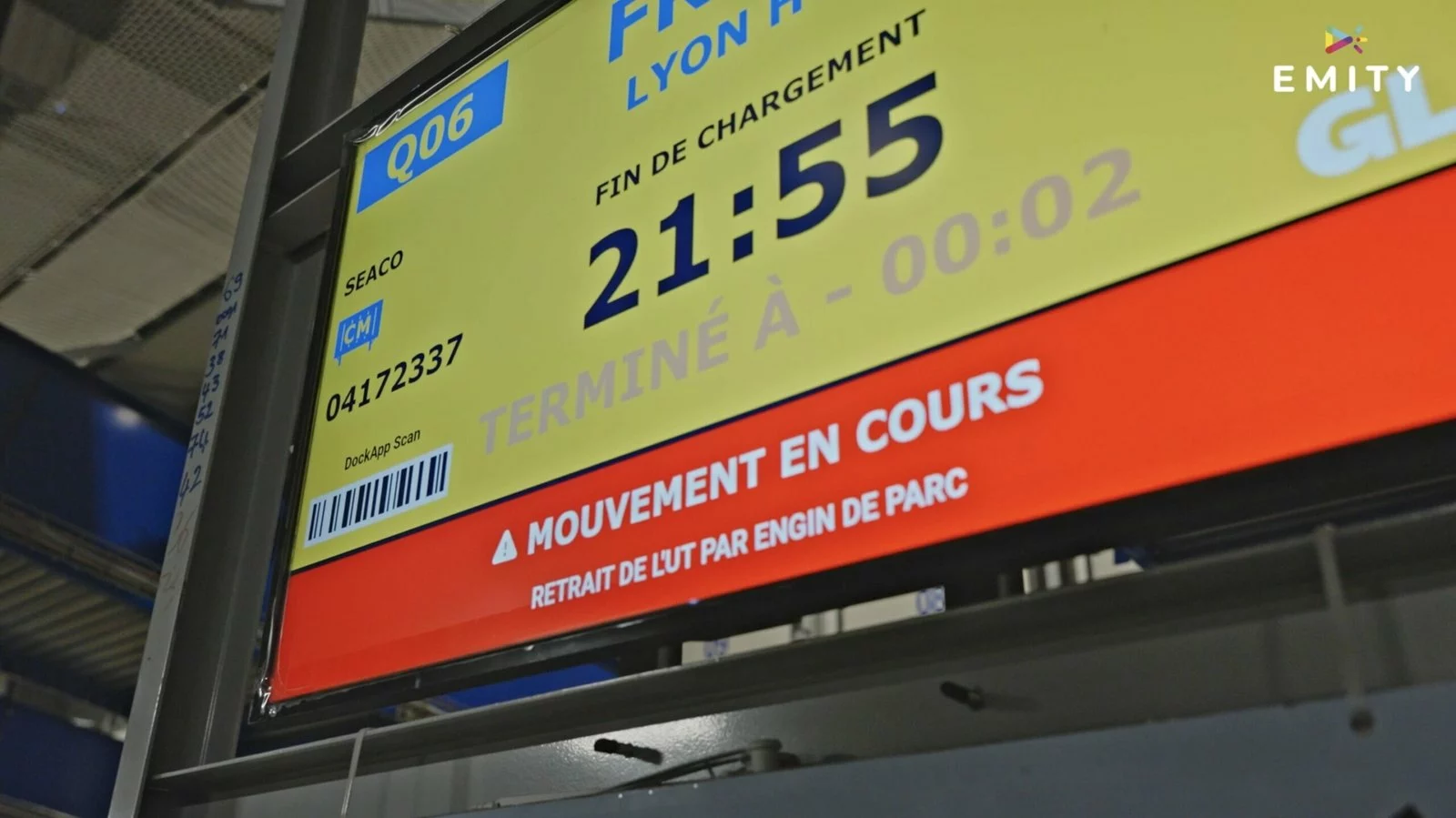 Écran de quai GLS affichant la destination et l'heure de fin de chargement, barré d'un bandeau rouge « Mouvement en cours »