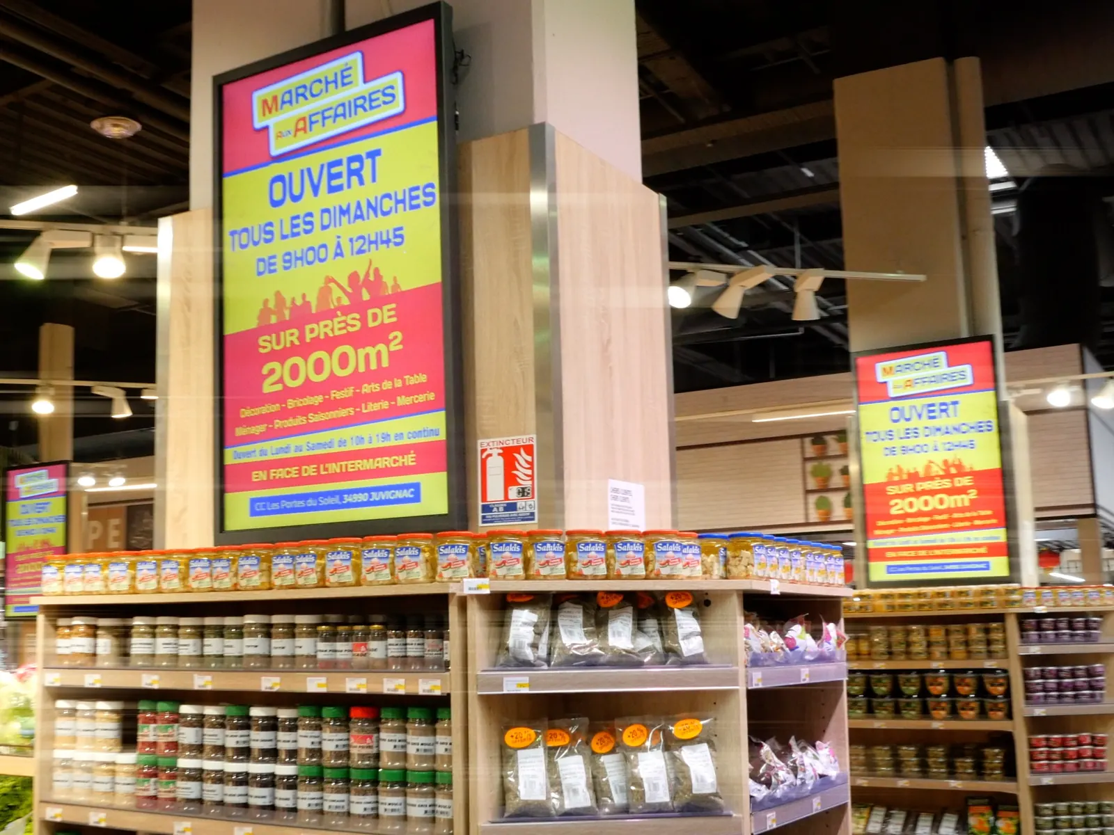 Deux écrans diffusant la même offre en bout de rayon dans un supermarché