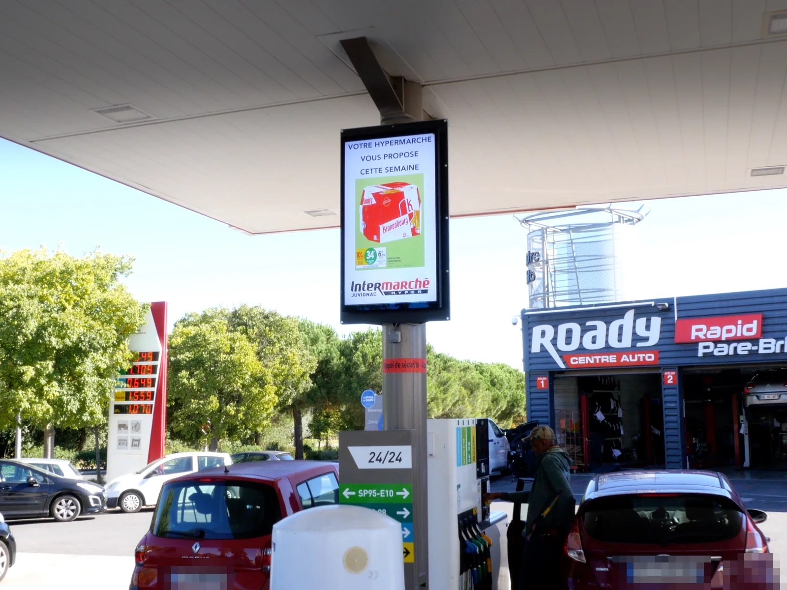 Écran d'affichage dynamique sous l'auvent d'une station-service de supermarché