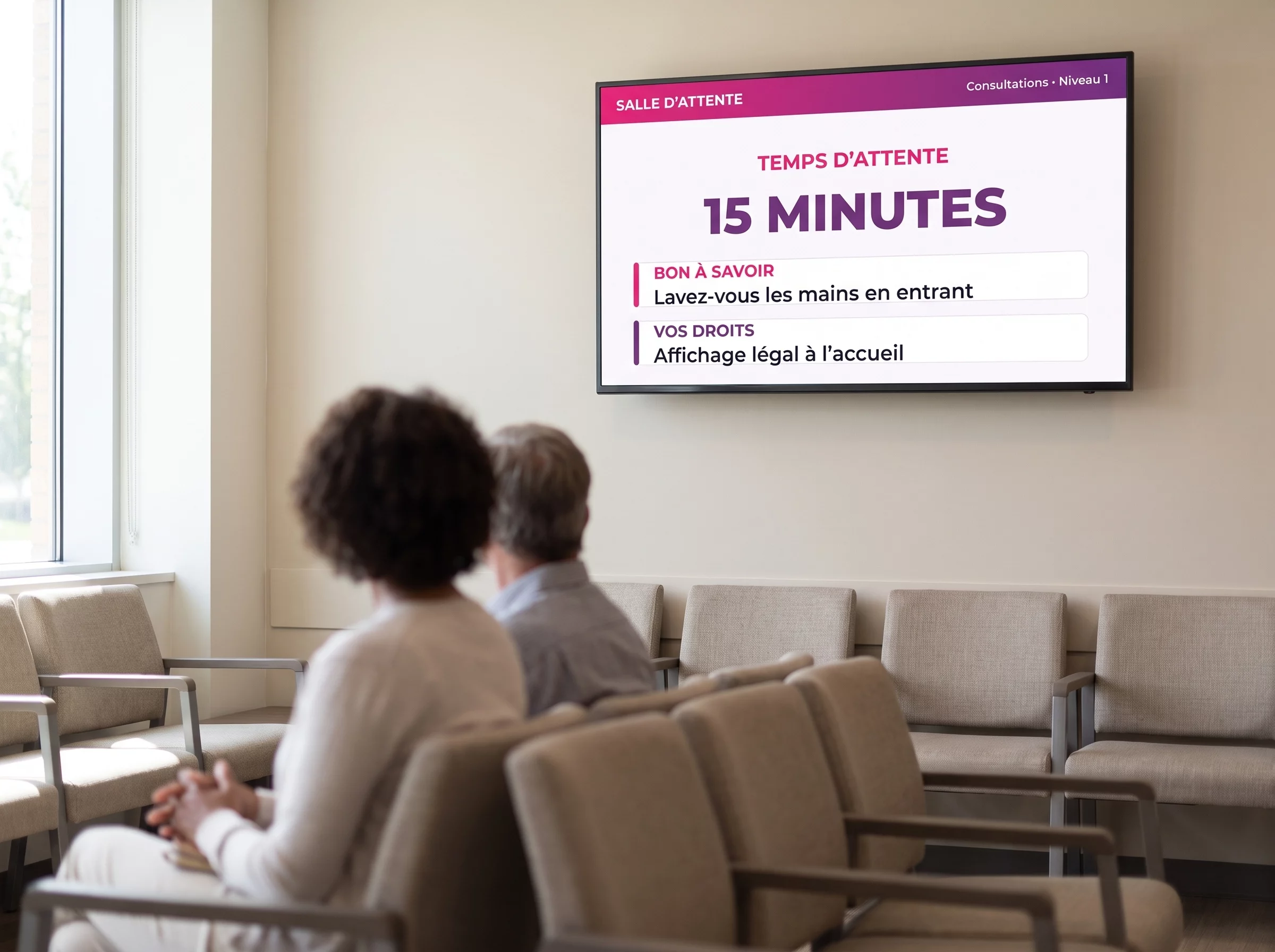 Écran en salle d'attente de consultations annonçant un temps d'attente de quinze minutes et des consignes d'hygiène