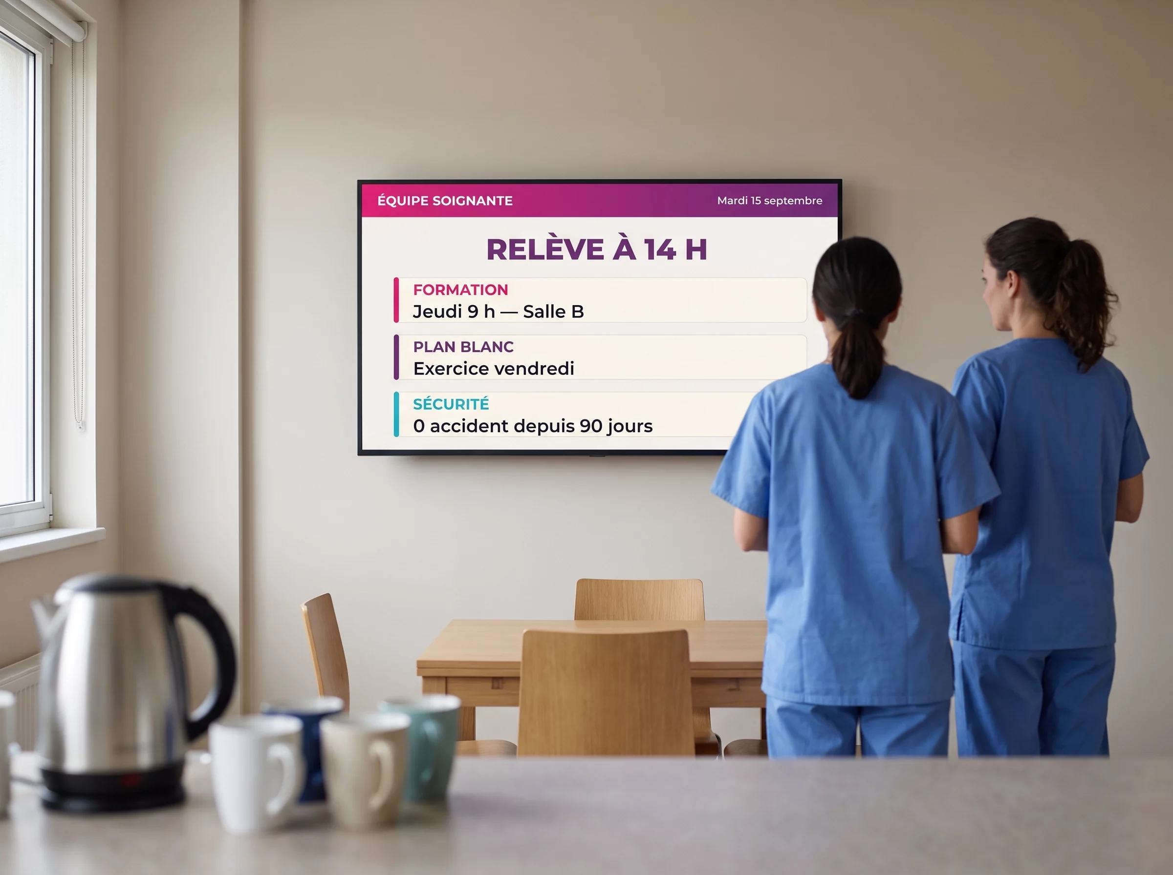Écran de communication interne dans une salle de pause hospitalière, annonçant l'heure de la relève et les informations de l'équipe soignante