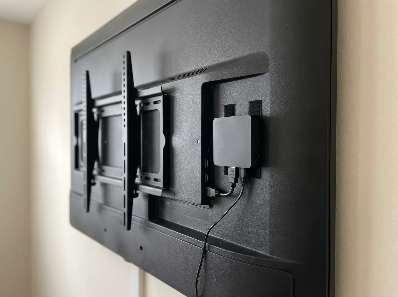 Part posterior d'una pantalla mural: el reproductor compacte E-BOX fixat darrere del panell, connectat per HDMI