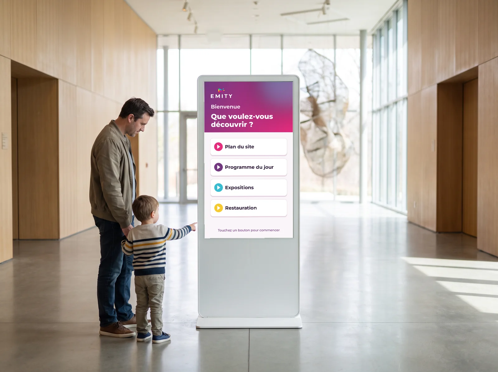 Père et enfant devant une borne tactile E-CLICK « Que voulez-vous découvrir ? » dans le hall d'un musée : plan du site, programme du jour, expositions, restauration