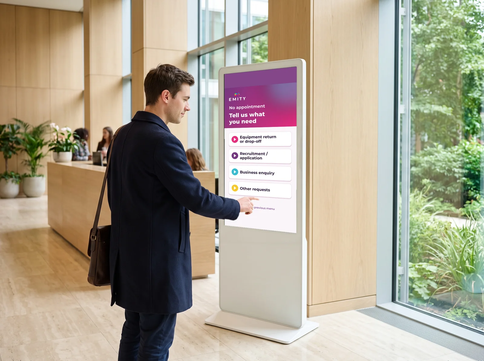 Visitor specifying their request on an E-CLICK touch kiosk in a lobby
