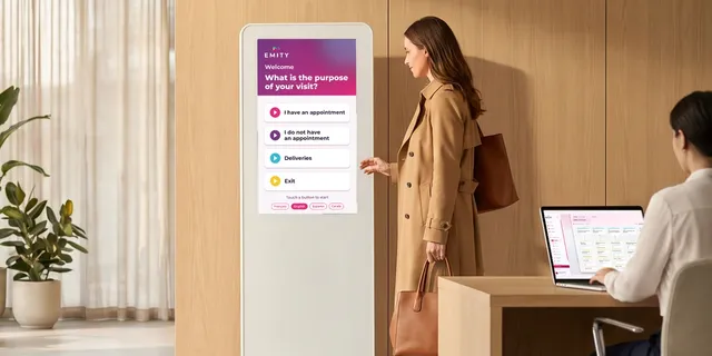 Visitor at an EMITY touch kiosk in a reception hall