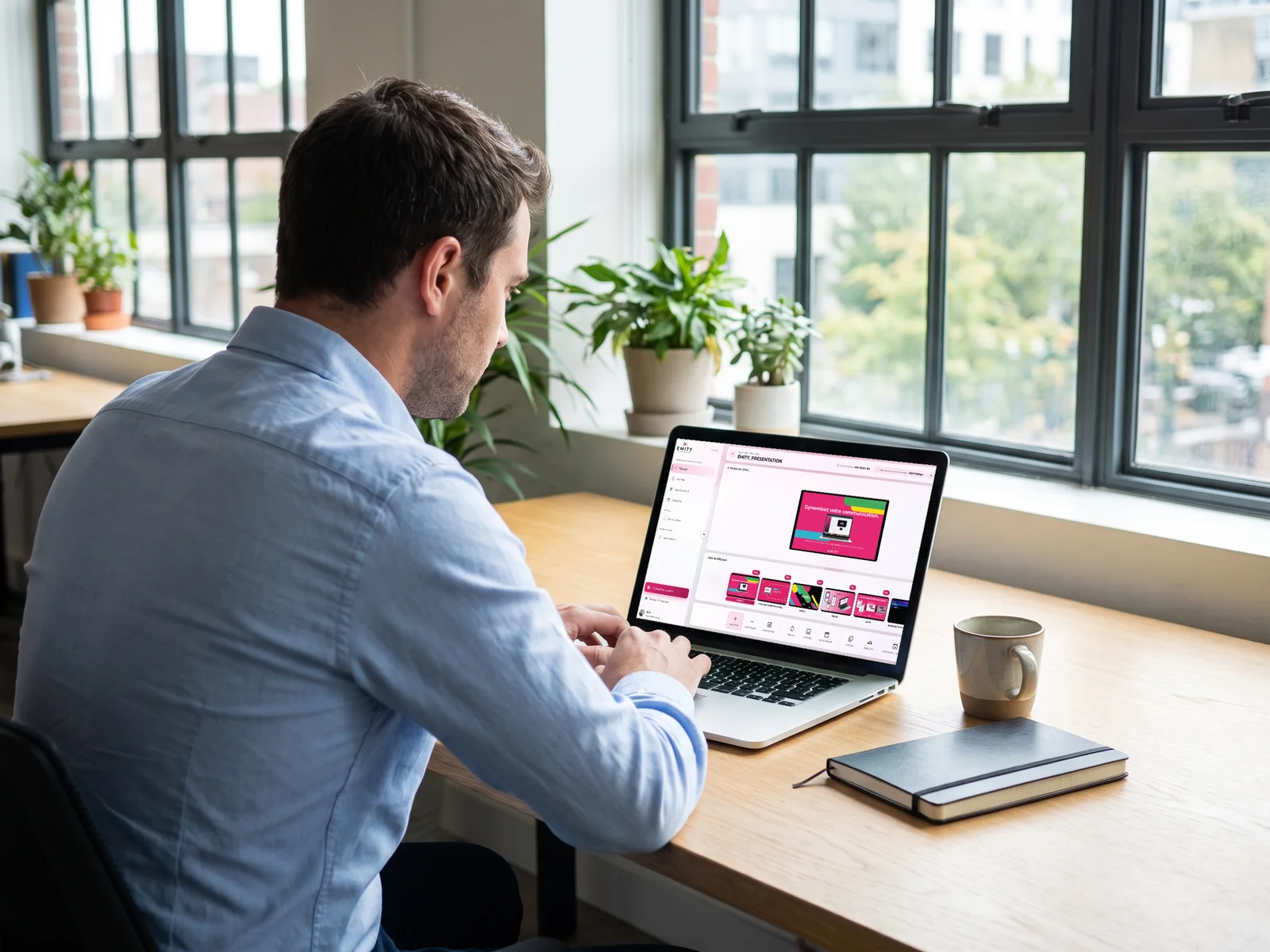 Collaborateur à son bureau qui programme une affiche dans E-MANAGER sur son ordinateur portable