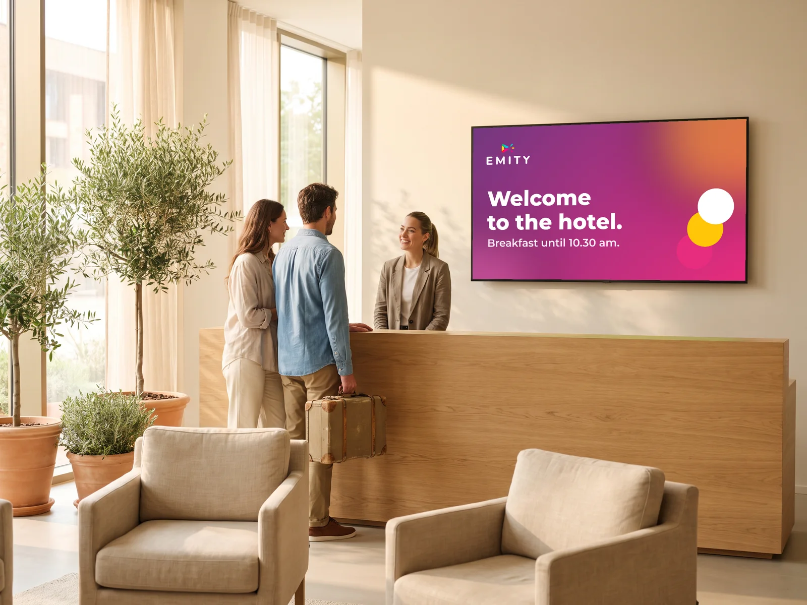 Couple welcomed at a hotel reception, under a welcome screen