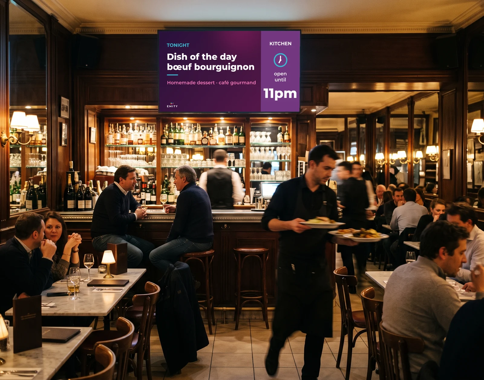 Paris brasserie in the evening: screen above the bar “Tonight · Dish of the day, bœuf bourguignon · kitchen open until 11pm”