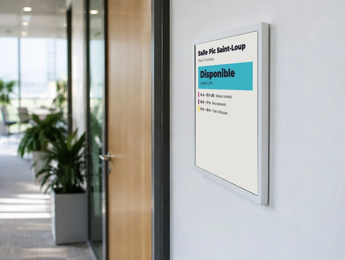 Affichette e-paper à la porte d'une salle de réunion indiquant « Disponible » et les réunions de la journée