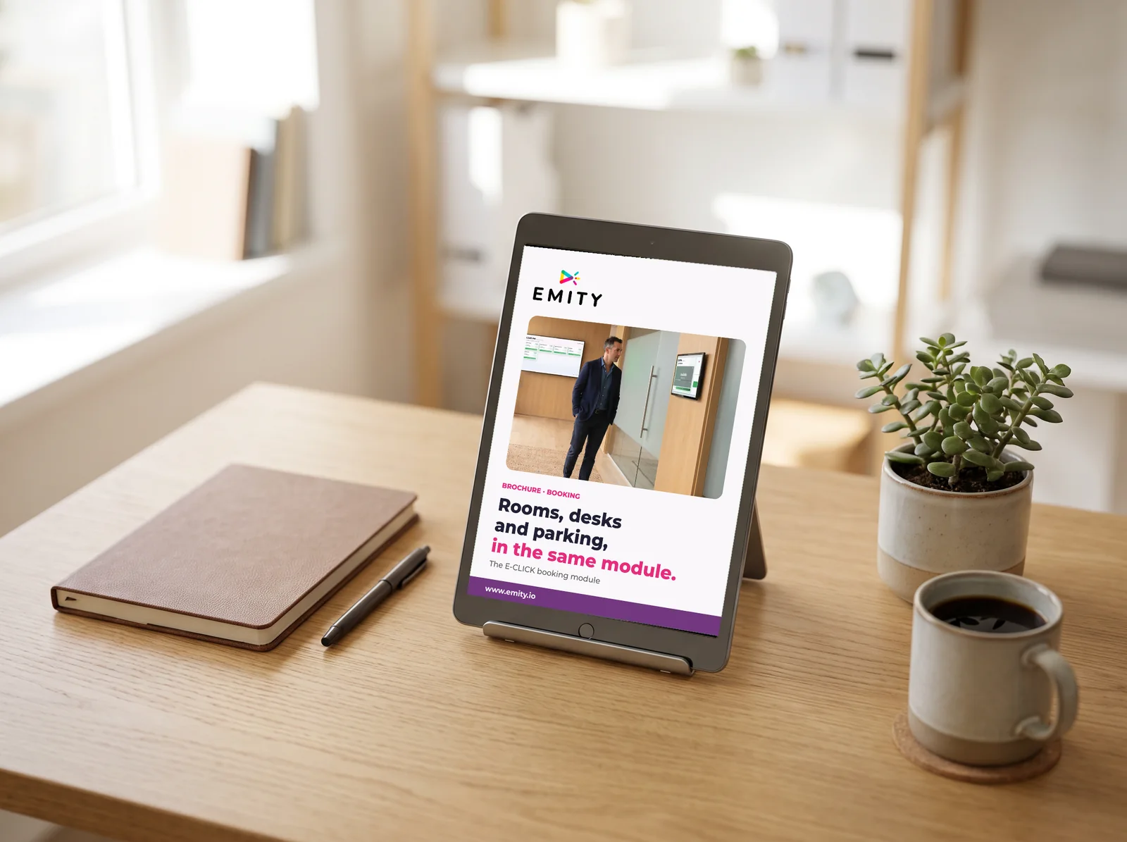 Tablet on a desk showing the cover of the EMITY booking brochure