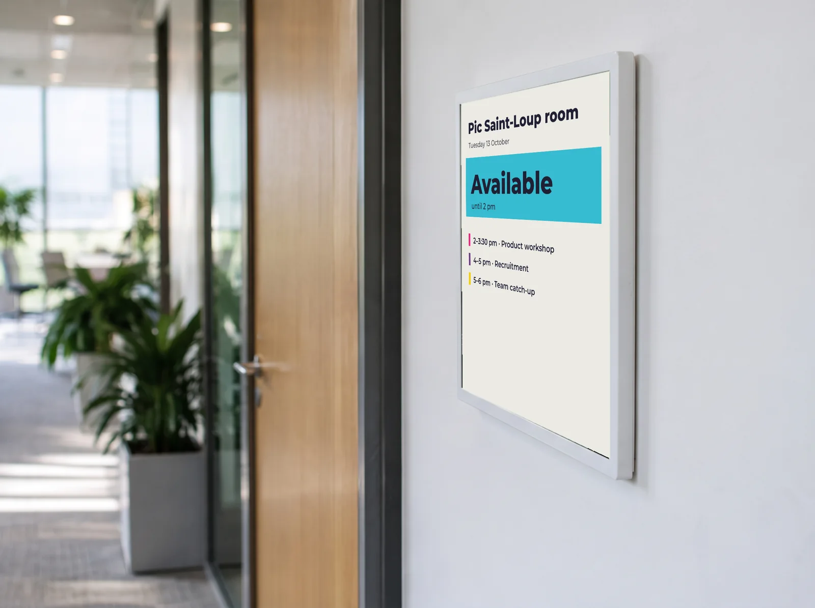 E-paper display at a meeting room door, showing the room as available and the day's bookings