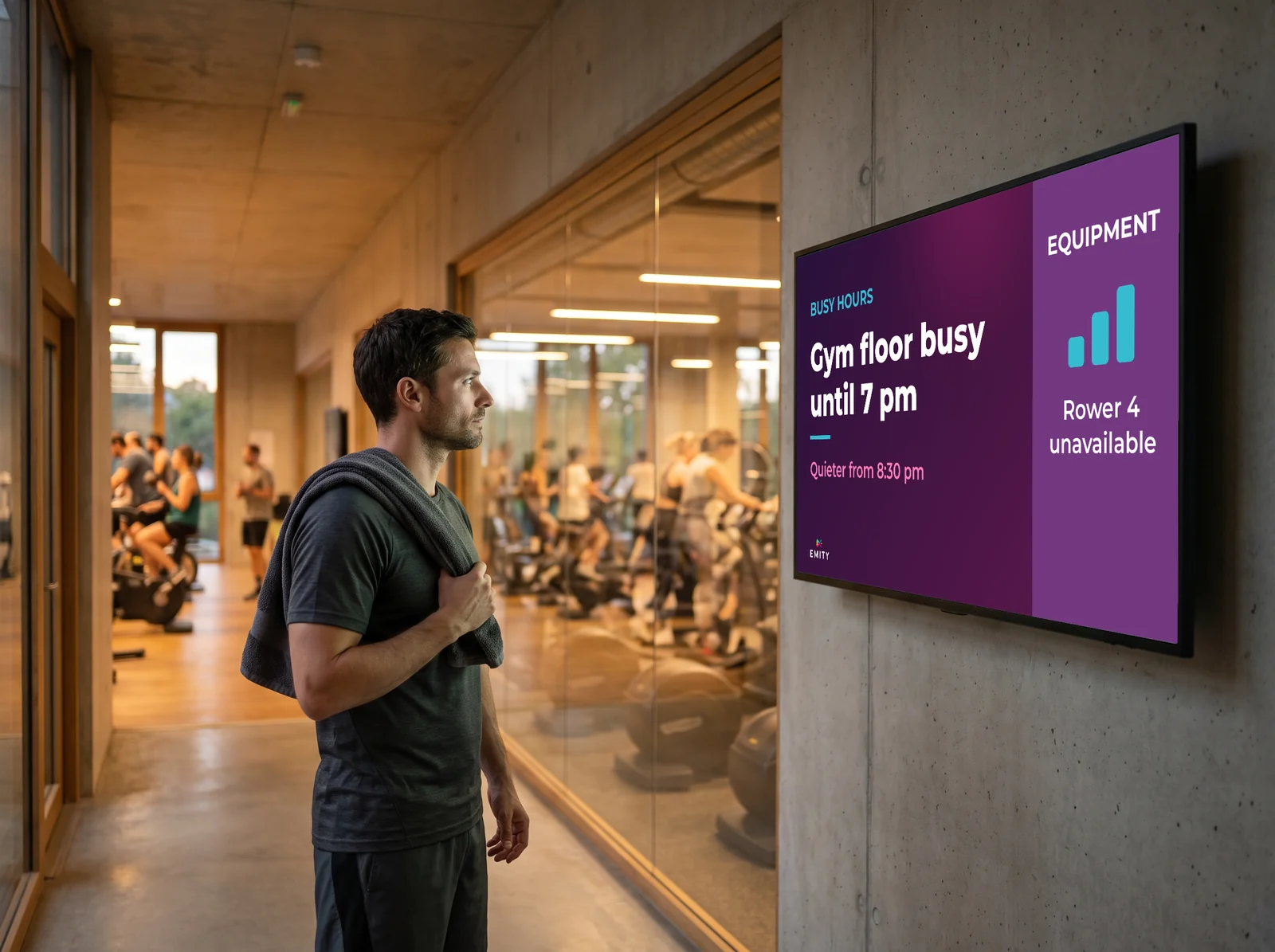 Member checking the crowd-level screen before heading to the gym floor: busy until 7 pm, one rower unavailable